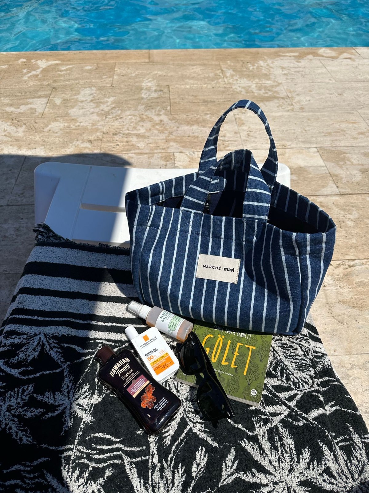 A striped poolside bag with towels and essentials