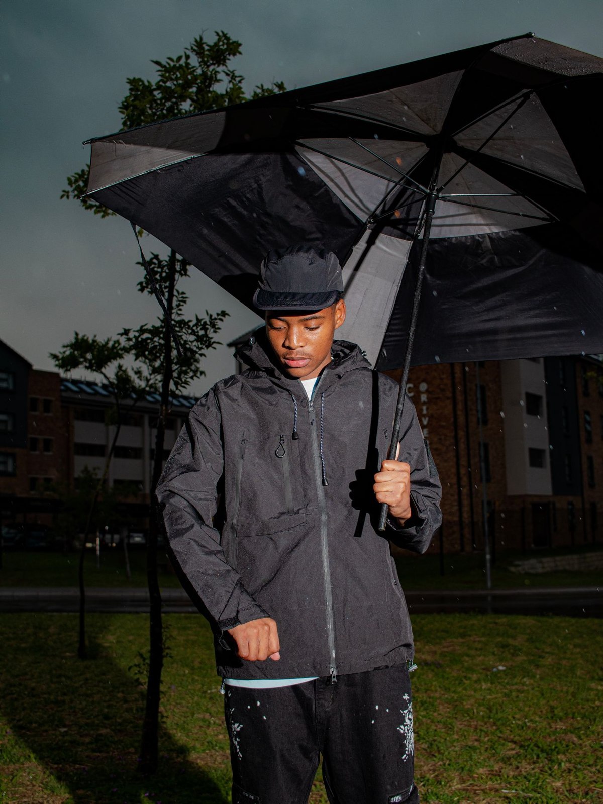 Dark outerwear under an umbrella in rain