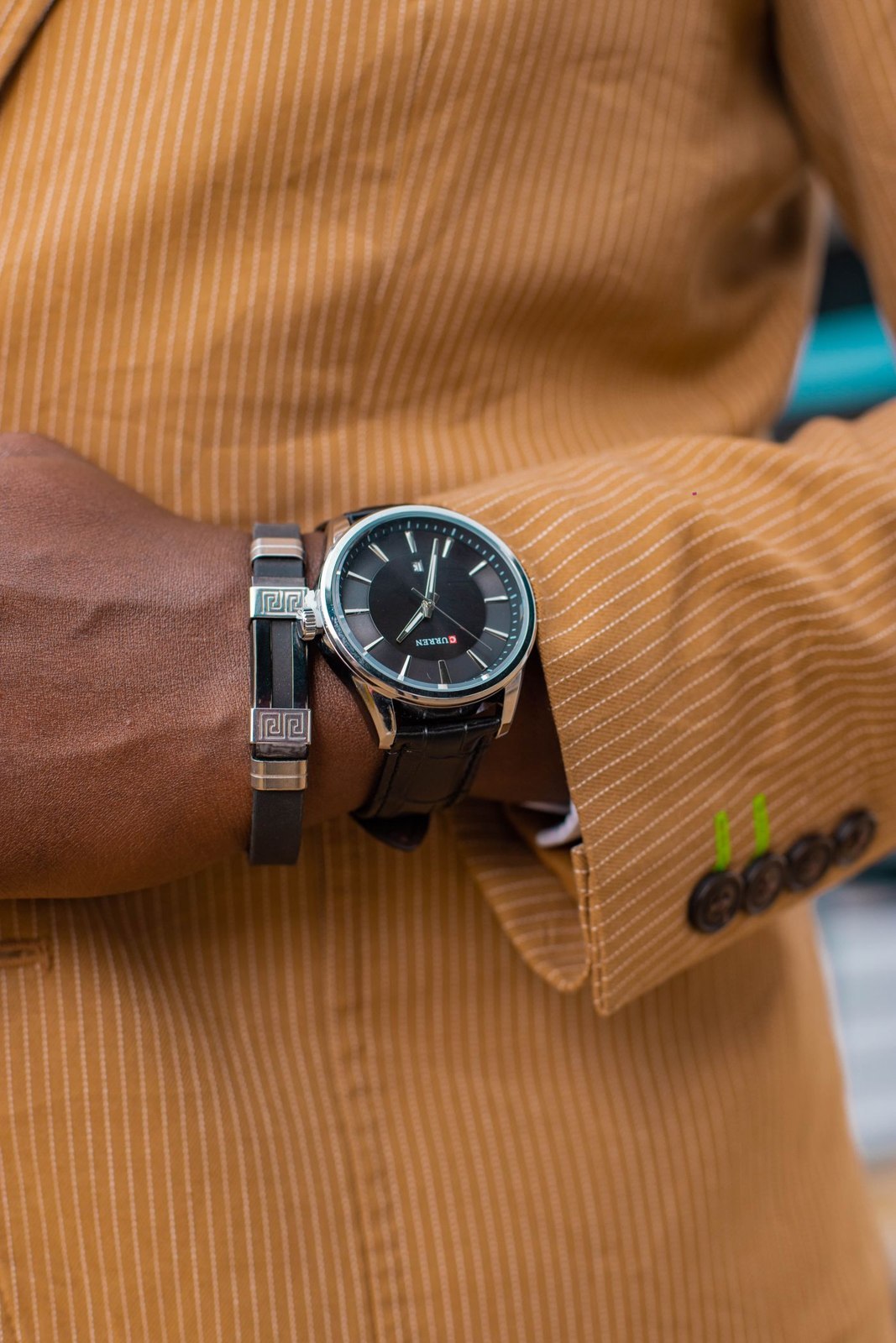 A simple watch beside a corduroy cuff