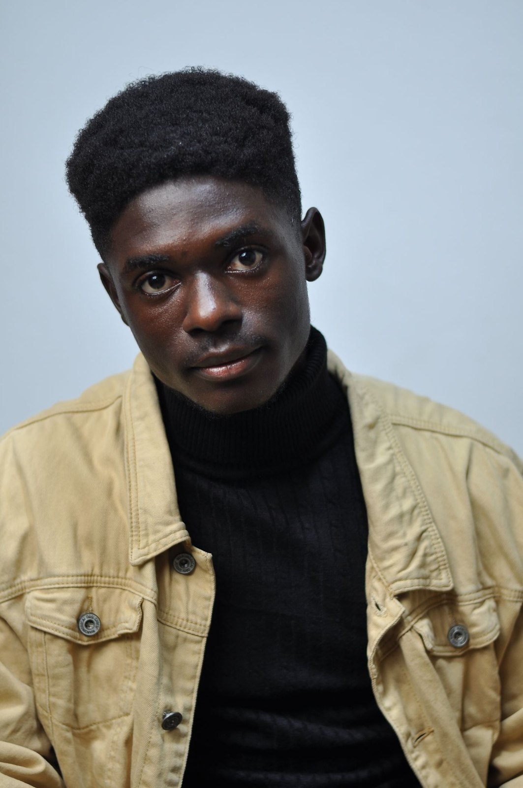 A thin dark roll-neck layered under a light jacket