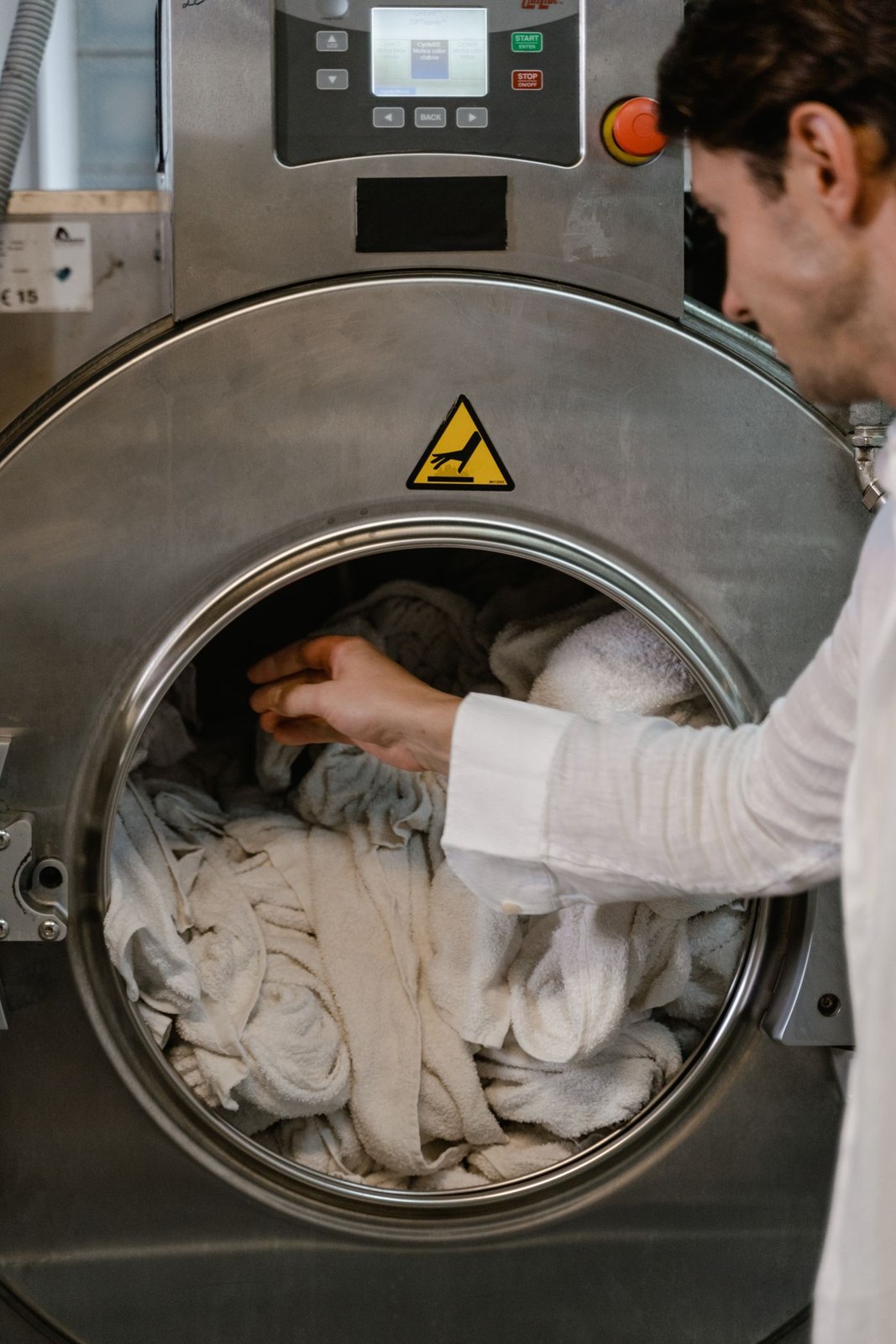 Light garments being loaded into a laundry machine