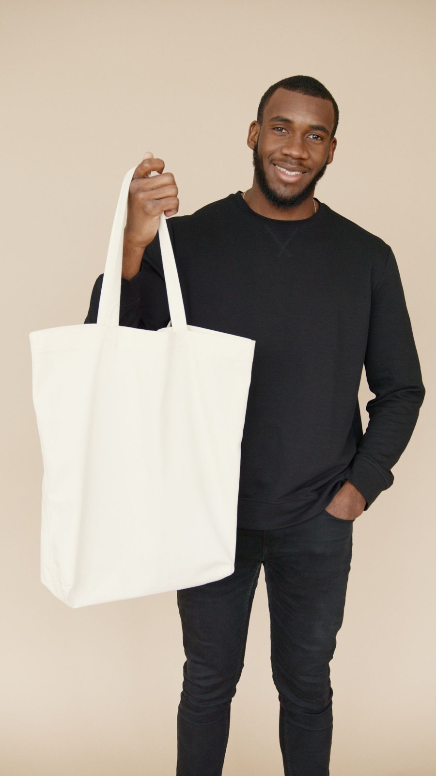 A plain canvas tote carried by hand