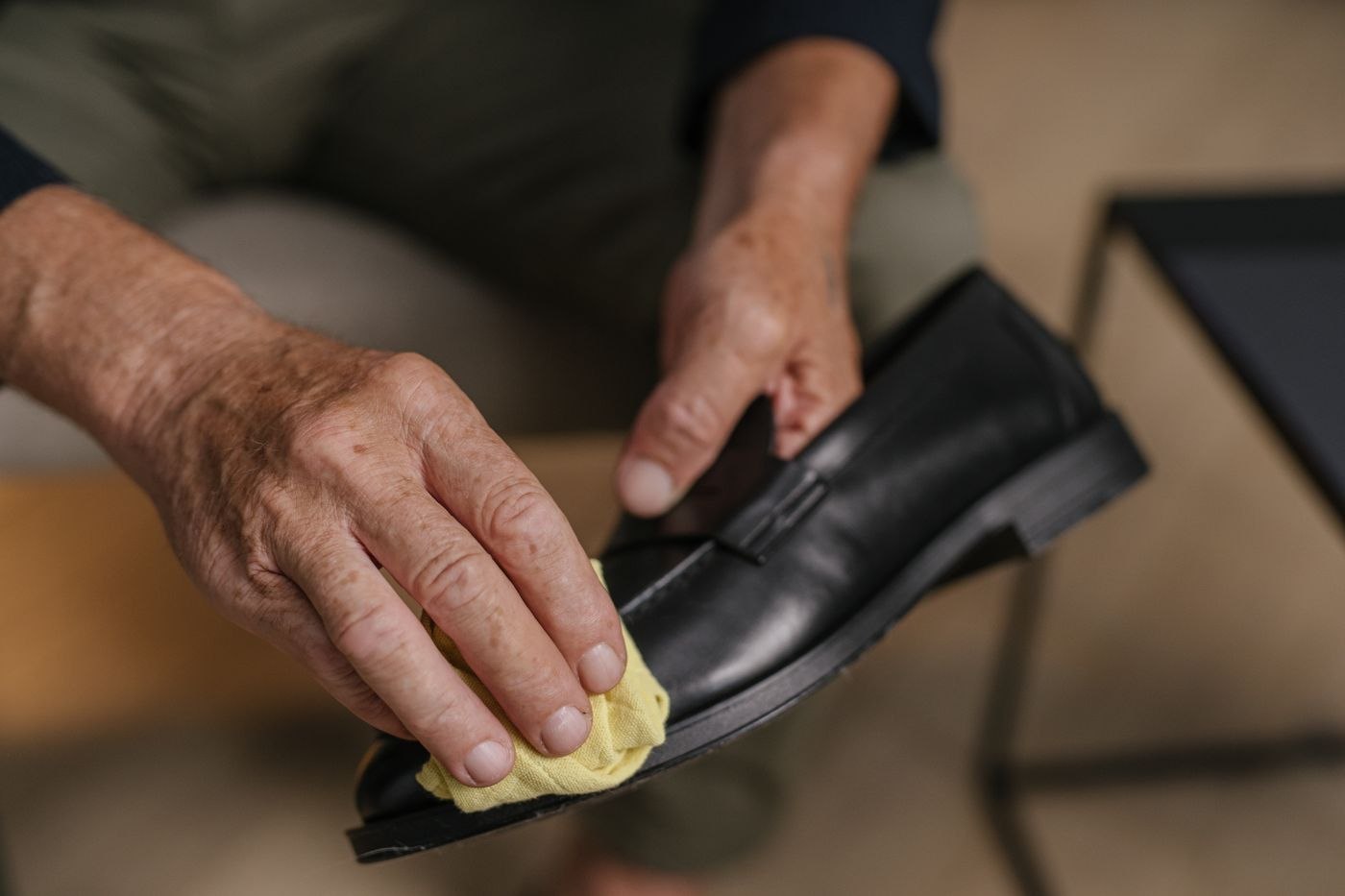 Gently polishing a black leather shoe