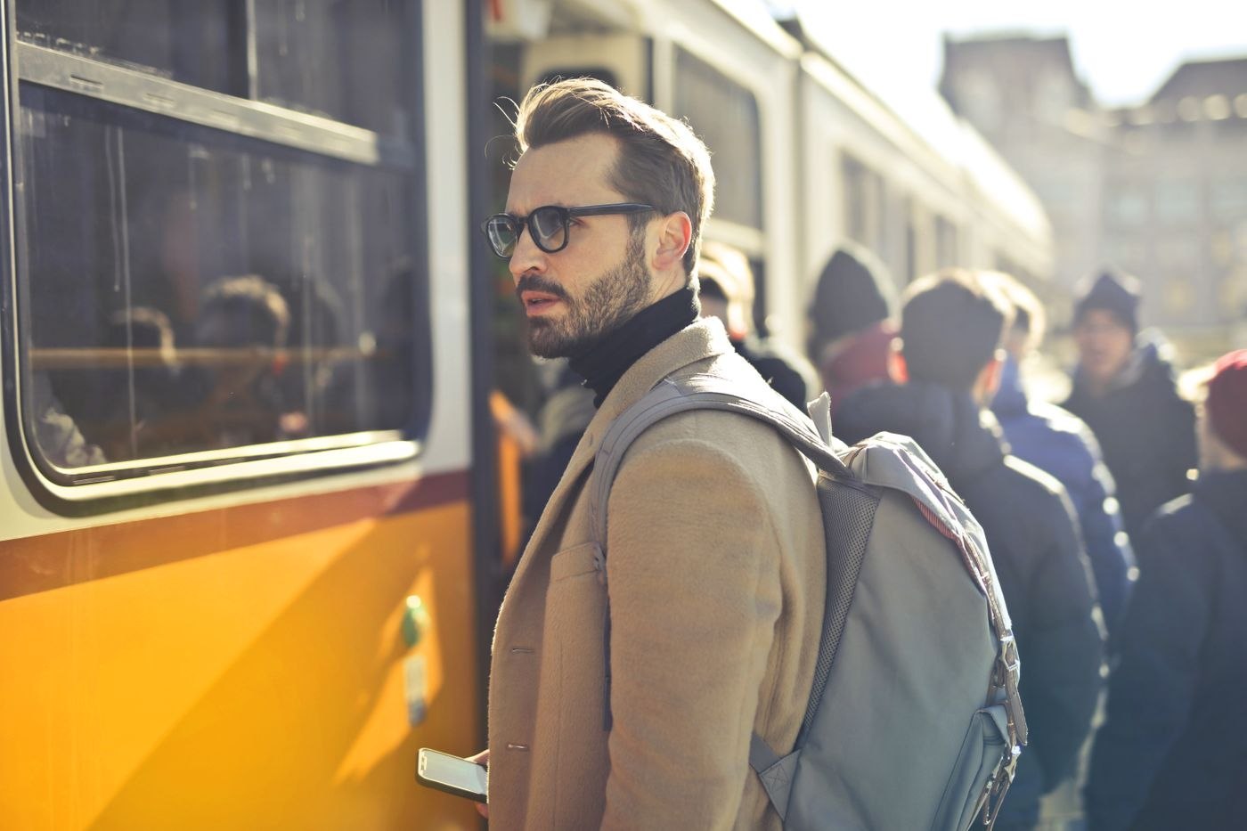 A layered outfit with a backpack by a tram