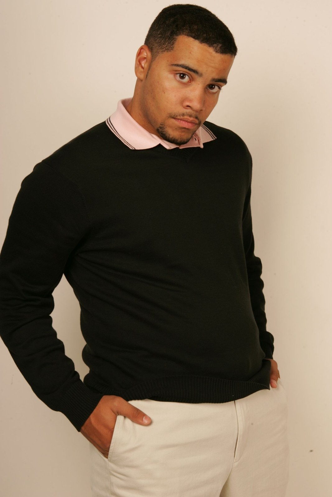 A dark crew-neck knit above light trousers