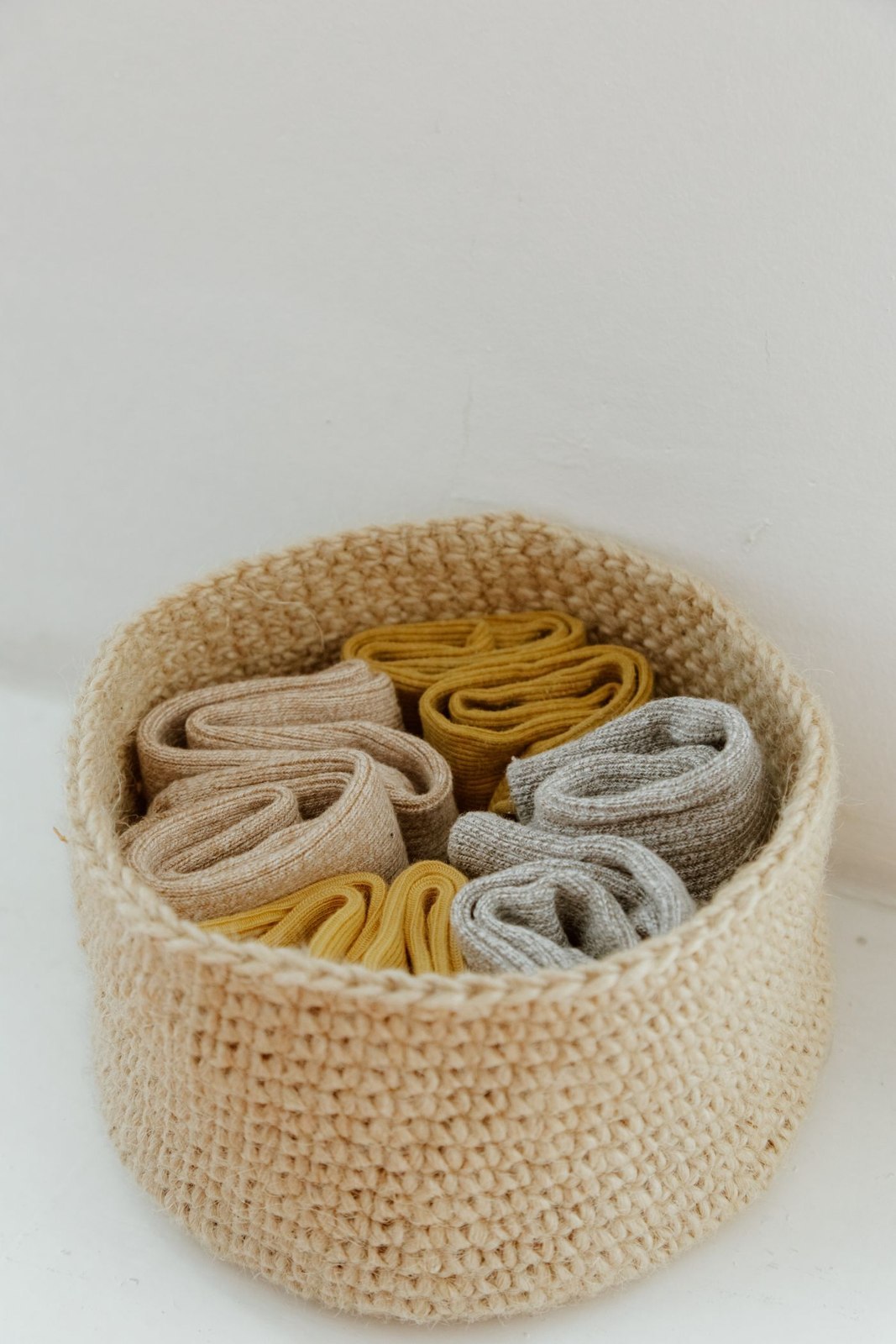 Rolled socks arranged in a small basket