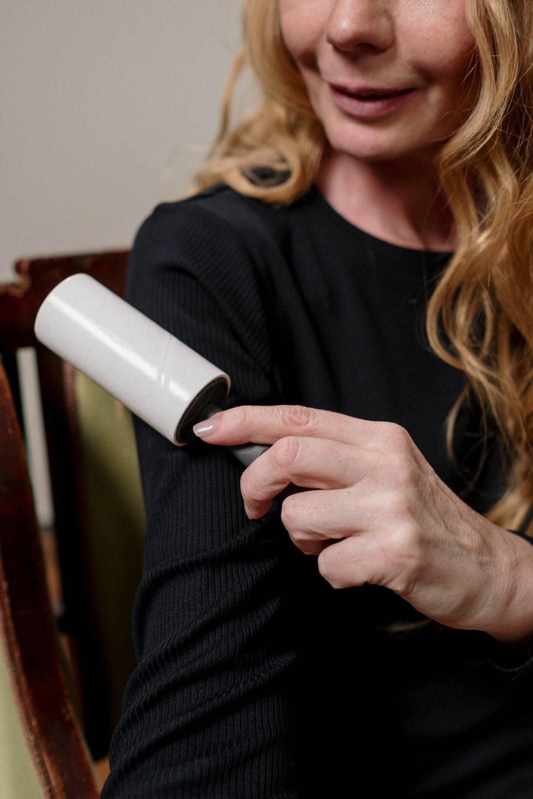 A lint roller used on a dark sleeve